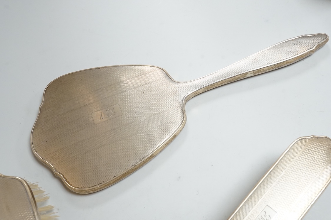 An early 1960's silver mounted hand mirror, 24.7cm and two matching brushes, Adie Bros. Birmingham, 1960.